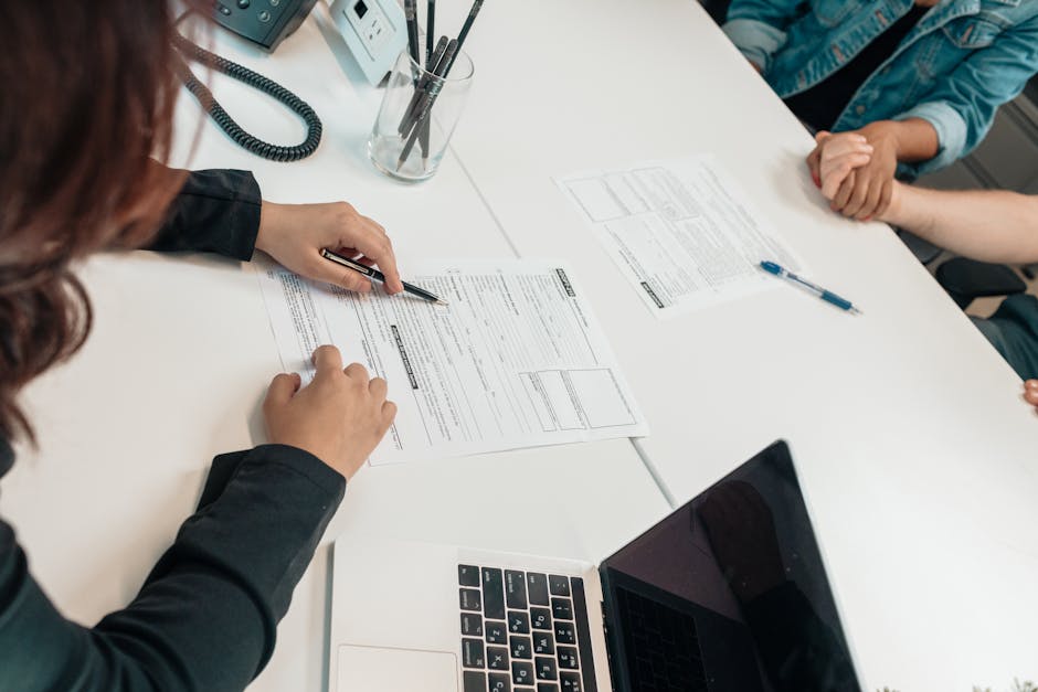 A professional meeting with document signing at an office desk, focusing on teamwork.